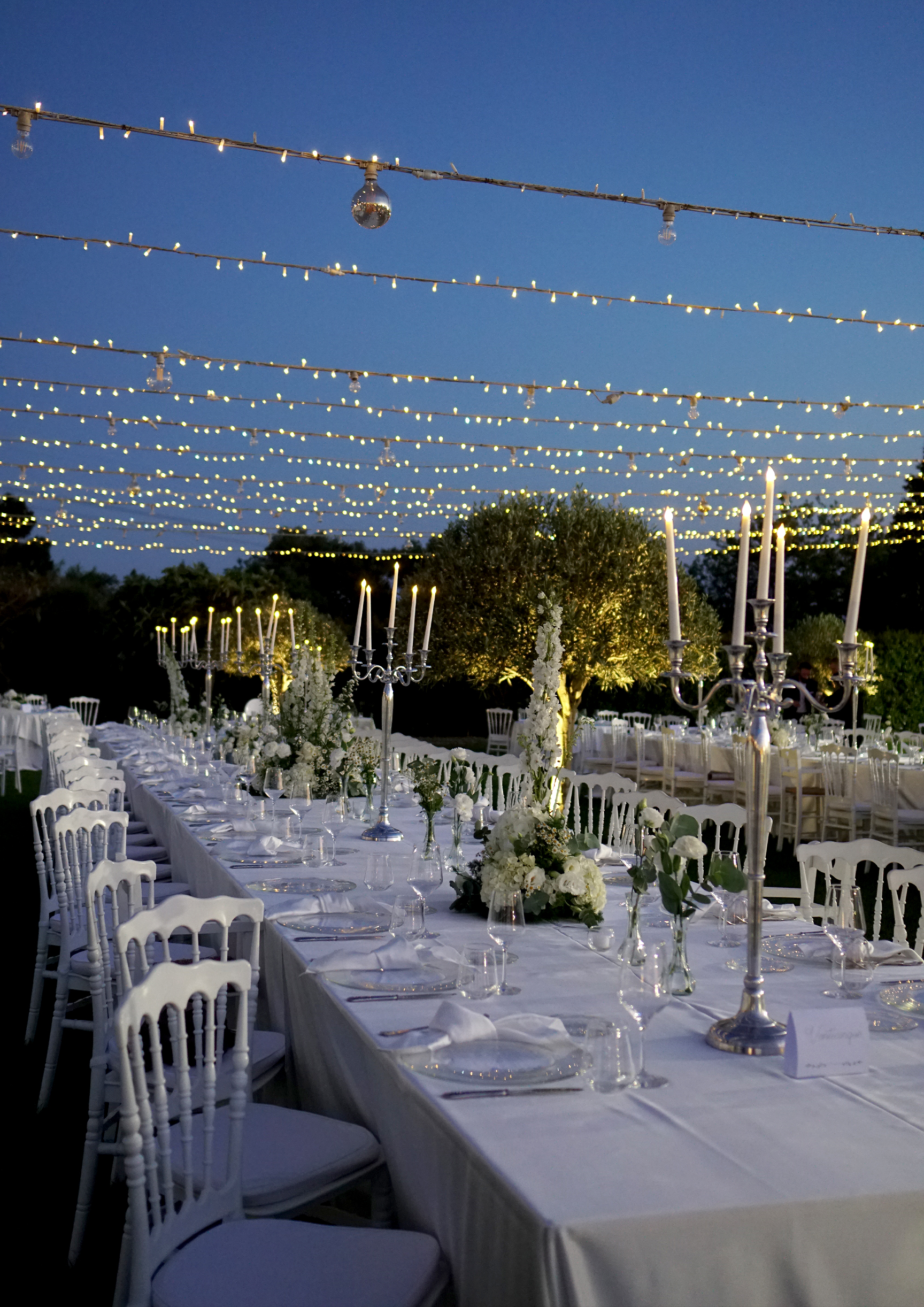 Tavolo imperiale con candelabri e luci a festa sotto il cielo della villa