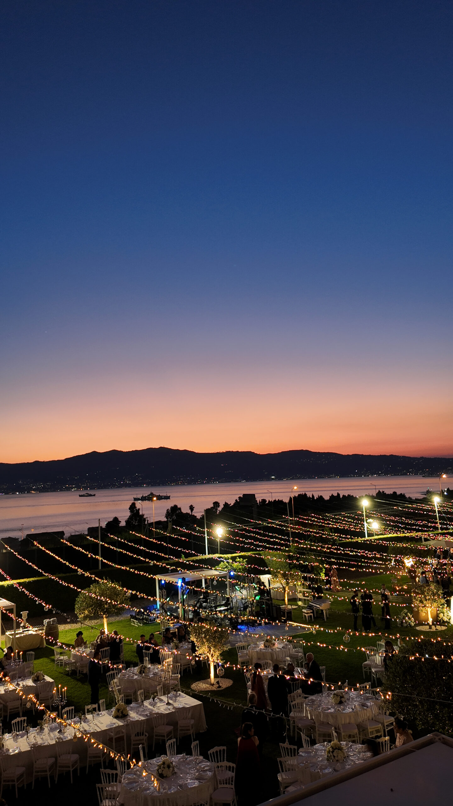 Vista aerea della villa illuminata al blu dell'ora magica sullo Stretto di Messina